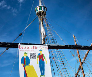 Bristol dockers sign: illustratio of dock porters hanging from mast of old ship