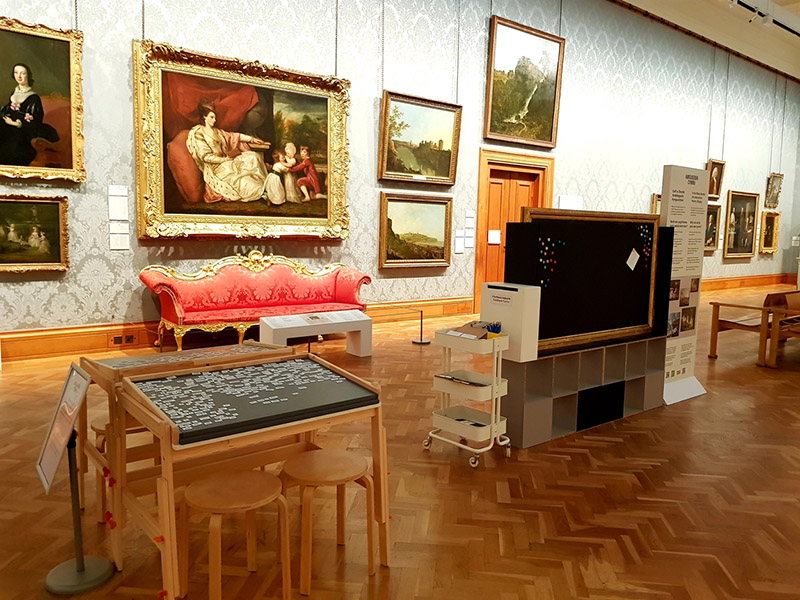 Art gallery at National Museum, Wales, Cardiff with wall-mounted paintings, magnetic boards: one with with alphabetical tiles and one with sets of words